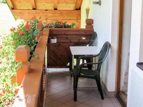 a table and chairs on a balcony with flowers at Holiday Home Rossbrand by Interhome in Radstadt