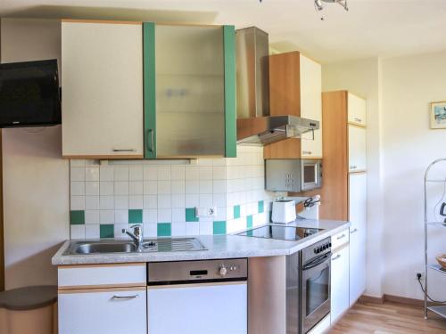 Una cocina con gabinetes verdes y un fregadero. en Apartment Rossbrand by Interhome, en Radstadt