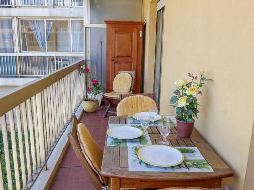 - une table en bois sur un balcon avec une table et des chaises dans l'établissement Apartment Le Poséidon by Interhome, à Cagnes-sur-Mer