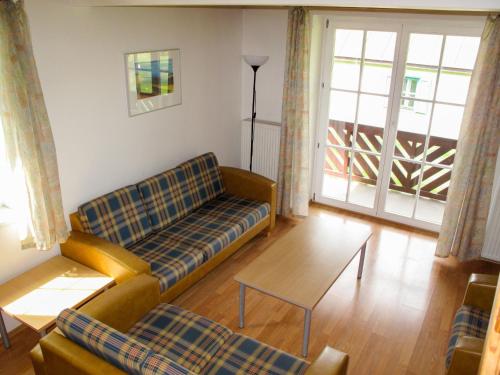 een woonkamer met een bank en een tafel bij Holiday Home Holiday Hill 36 by Interhome in Lauterwasser