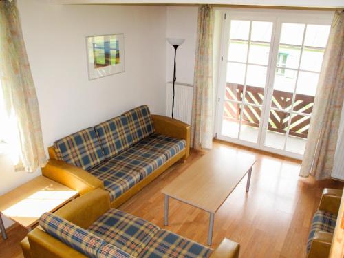 ein Wohnzimmer mit einem Sofa und einem Tisch in der Unterkunft Holiday Home Holiday Hill 45 by Interhome in Lauterwasser