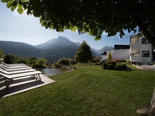 a picnic table in the grass with a view of mountains at Apartment Oberhofer-5 by Interhome in Telfes im Stubai