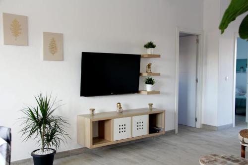 uma sala de estar com uma televisão de ecrã plano na parede em Casa Los Molinos em Villaverde
