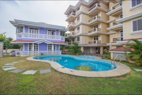 un gran edificio de apartamentos con piscina frente a él en Dona Rosa Holiday Apartment, en Varca