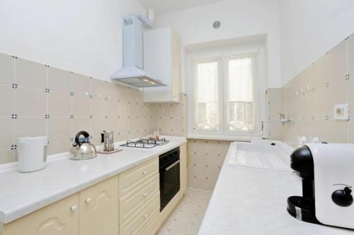 a white kitchen with a sink and a stove at Balestra in Rome