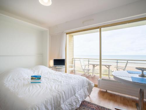 une chambre avec un lit et une vue sur l'océan dans l'établissement Studio Le Golf-1 by Interhome, à Cabourg