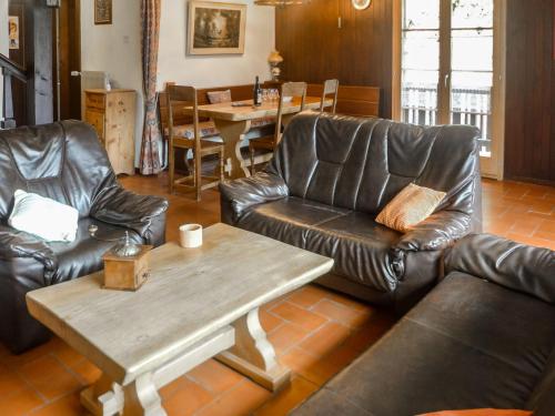 a living room with leather furniture and a table at Apartment Chalet l'Aube by Interhome in Vers L'Eglise