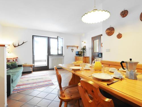 - un salon avec une table et des chaises en bois dans l'établissement Apartment Casa Marmolada by Interhome, à Penia