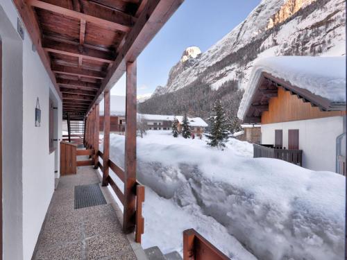 un balcone innevato di un edificio con una montagna di Apartment Casa Marmolada by Interhome a Penia