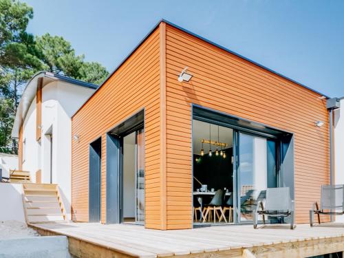 an orange and white house with a deck at Holiday Home Palot 63 by Interhome in Mimizan