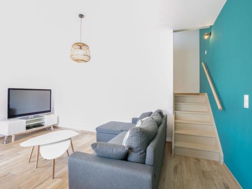 a living room with a couch and a tv at Holiday Home Palot 63 by Interhome in Mimizan