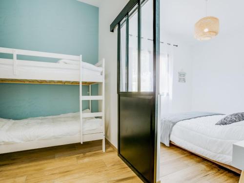 a bedroom with two bunk beds and a glass door at Holiday Home Palot 63 by Interhome in Mimizan