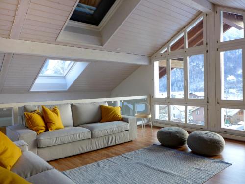 ein Wohnzimmer mit einem Sofa und einigen Fenstern in der Unterkunft Apartment Belvedere by Interhome in Brienz