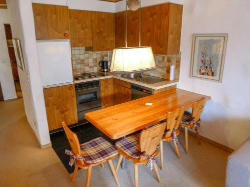 a kitchen with a wooden table and some chairs at Apartment Muotta Sulegl by Interhome in Schleuis