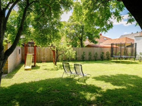 two chairs sitting in a yard next to a fence at Holiday Home Marian by Interhome in Balatonboglár
