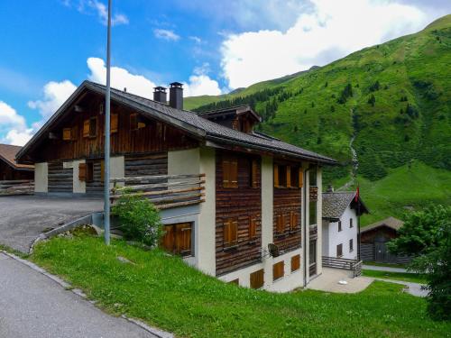 a wooden house on a hill with a mountain at Apartment Alpetta by Interhome in Tschamut