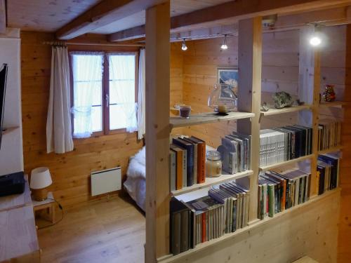 a room with two shelves filled with books at Apartment Alpetta by Interhome in Tschamut