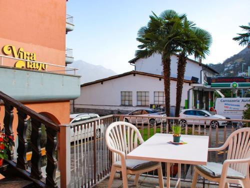 a table and chairs on a balcony with a palm tree at Apartment App- Vira Lago 500 Ost - EG by Interhome in Vira