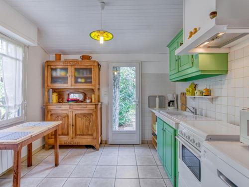 une cuisine avec des placards verts et une table dans l'établissement Holiday Home Pignada by Interhome, à Mimizan