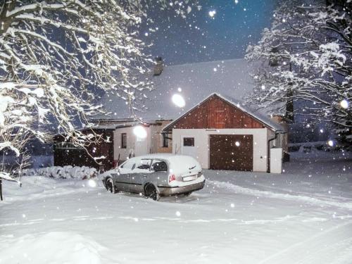 a car parked in the snow in front of a house at Holiday Home Rokytnice v Orlických horách by Interhome in Pěčín