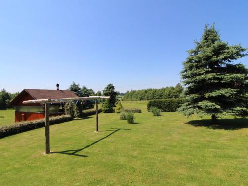 a tree in the middle of a field with a house at Holiday Home Rokytnice v Orlických horách by Interhome in Pěčín