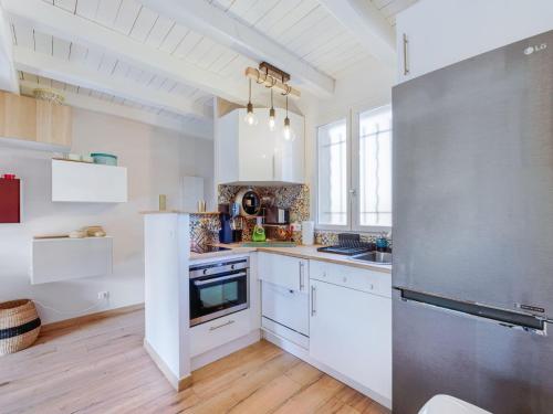 une cuisine avec des armoires blanches et un réfrigérateur en acier inoxydable dans l'établissement Apartment Les Lantanas-2 by Interhome, à Cavalaire-sur-Mer