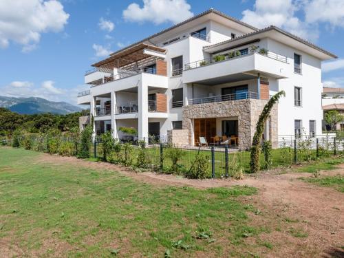 une maison blanche avec une clôture devant dans l'établissement Apartment Domaine d'Arca-2 by Interhome, à Porto-Vecchio