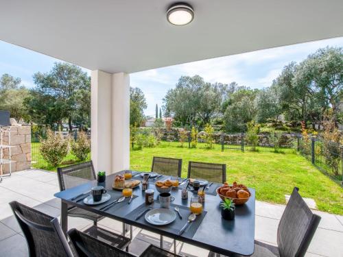 une table avec de la nourriture dessus sur une terrasse dans l'établissement Apartment Domaine d'Arca-2 by Interhome, à Porto-Vecchio