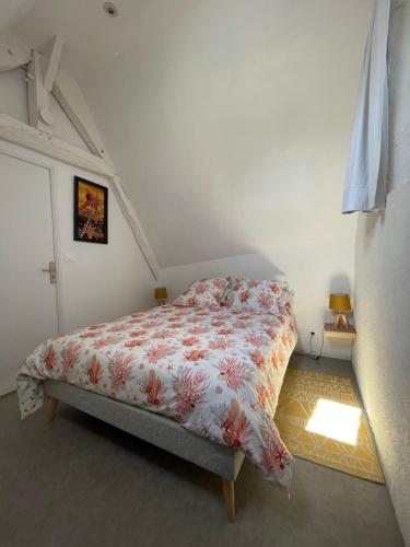 1 dormitorio con 1 cama con edredón de flores en Le Penty, en Guimaëc