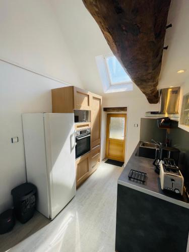 une cuisine avec un réfrigérateur blanc et un évier dans l'établissement Le Penty, à Guimaëc