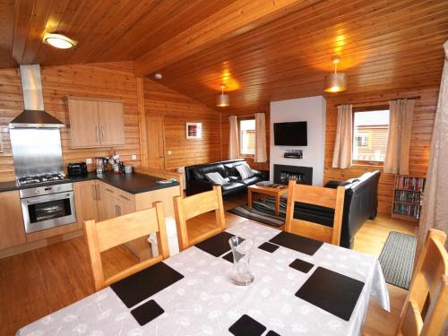 a kitchen and a living room with a table and chairs at Chalet Loch Leven Lodge 11 by Interhome in Kinross