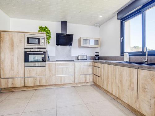 a kitchen with wooden cabinets and a sink at Holiday Home Peyroutic by Interhome in Aureilhan