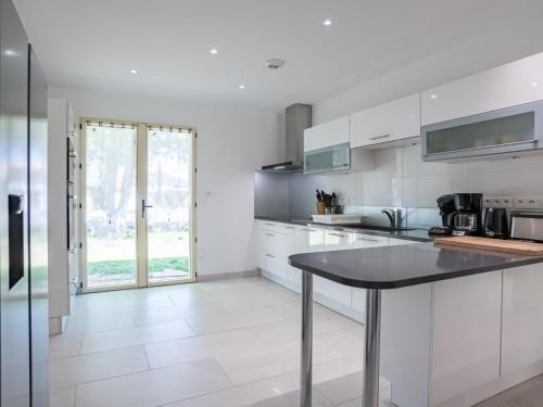 a kitchen with white cabinets and a table at Holiday Home Laouchet by Interhome in Pontenx-les-Forges