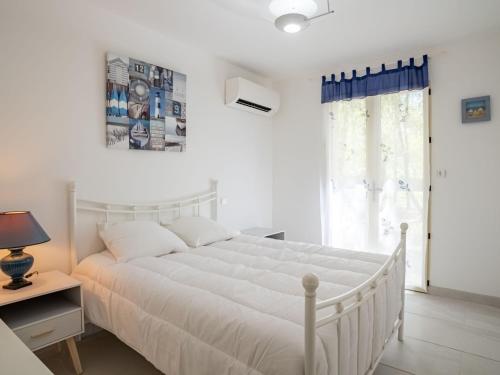 a white bedroom with a white bed and a window at Holiday Home Laouchet by Interhome in Pontenx-les-Forges