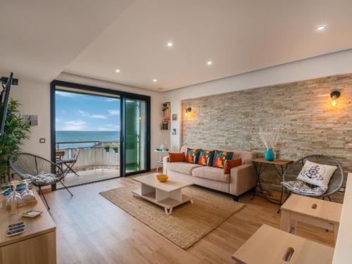 a living room with a couch and a brick wall at Apartment S'Illot-Cala Morlanda by Interhome in S'Illot