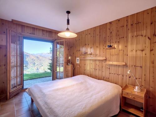 a bedroom with a bed and a large window at Chalet Les 4 Saisons by Interhome in Veysonnaz