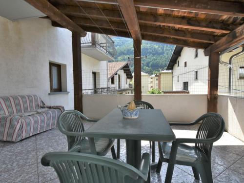 a table and chairs on a balcony with a couch at Apartment Grosio Terrace by Interhome in Grosio