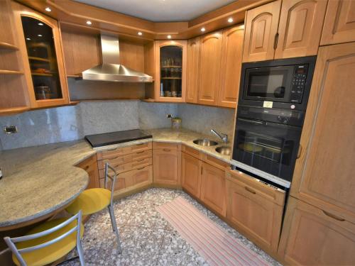 a kitchen with wooden cabinets and a sink and a stove at Apartment Grosio Terrace by Interhome in Grosio