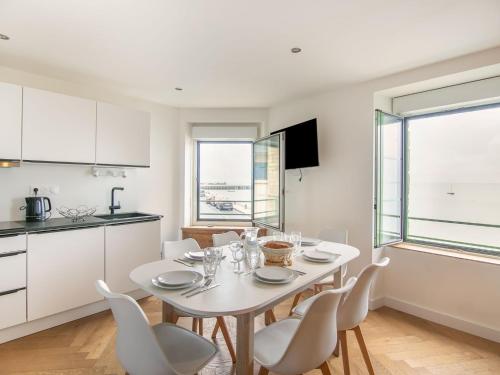 une cuisine et une salle à manger avec une table et des chaises blanches dans l'établissement Apartment Le point du jour 1 by Interhome, à Cancale