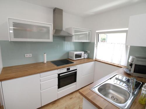 a kitchen with white cabinets and a sink at Holiday Home Leopoldau by Interhome in Vienna