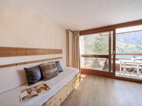 1 dormitorio con 1 cama y ventana grande con mesa en Studio Palafour - Le Lac-4 by Interhome en Tignes