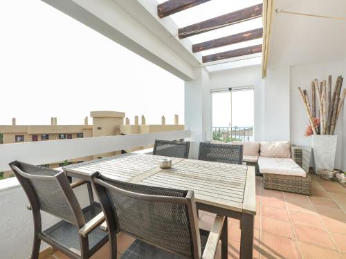 ein Esszimmer mit einem Holztisch und Stühlen in der Unterkunft Apartment Alamar by Interhome in Mijas Costa