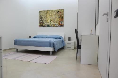Agorà-Akrai B&B في بالاتسولو أكريدي: غرفة نوم بسرير ودهان على الحائط