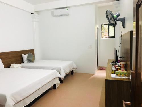 a hotel room with two beds and a clock on the wall at ANH ANH HOTEL in Bắc Hà