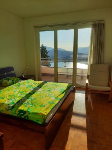 a bedroom with a bed and a large window at Appartamento Chicca in Lugano