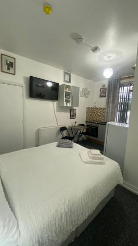 a bedroom with a white bed and a tv on the wall at BVapartments-Blackhouse F2 in Huddersfield