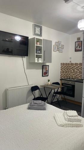 a room with a bed and a kitchen with a table at BVapartments-Blackhouse F2 in Huddersfield