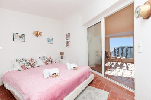 - une chambre avec un lit rose et un balcon dans l'établissement Sea View Duplex YourHostHelper, à Théoule-sur-Mer