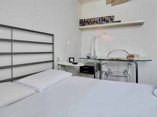 ein weißes Schlafzimmer mit einem Bett und einem Tisch in der Unterkunft Settembrini in Mailand