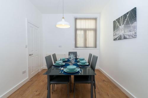 a dining room with a black table and chairs at House of Vacation in Portsmouth